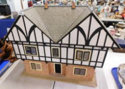 A late 20thC two storey wooden doll's house, with black and white beam effect upper overhanging