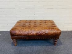 A contemporary rectangular tan leather stool