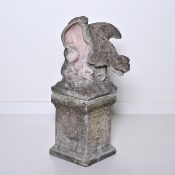 Decorative stone garden ornament of a winged mythical creature sitting on a plinth with a beautiful