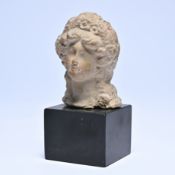 Antique terracotta bust of a female head, mounted on a black base