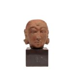 AN ANTIQUE INDIAN TERRACOTTA HEAD,