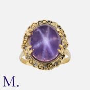A Star Sapphire And Diamond Ring in yellow gold, set with a principal cabochon star sapphire of