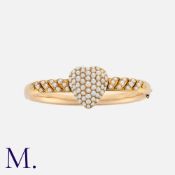 A Victorian Pearl Heart Locket Bangle in yellow gold, set with natural pearls in a pavé style with a