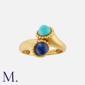 VAN CLEEF & ARPELS. A Turquoise and Lapis Lazuli Ring in 18ct yellow gold in a cross-over style.