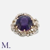 An Amethyst And Diamond Ring in white gold, set with a central round cut amethyst of approximately