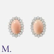 A Pair Of Coral And Diamond Earrings in white gold, each set with a cabochon coral of