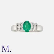 An Emerald and Diamond Ring in 18K white gold, set with an oval-cut emerald of approximately 0.40ct,