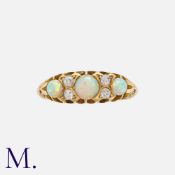 An Opal And Diamond Ring in 18k yellow gold, set with three cabochon opals punctuated by pairs of