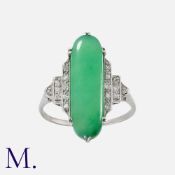An Art Deco Jade And Diamond Ring in platinum, set with an elongated jade cabochon of