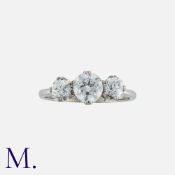 A Diamond Three Stone Ring in 18k white gold, set a central round cut diamond of approximately 0.