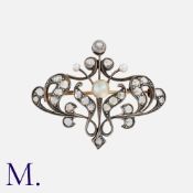 A Pearl And Diamond Brooch in yellow gold and silver, of scrolling foliate design, set with rose cut