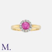 A Ruby And Diamond Cluster Ring in yellow gold, set with a central round cut ruby (synthetic) within