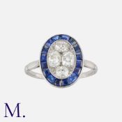 A Sapphire and Diamond Target Ring in platinum, set centrally with four old cut diamonds within a