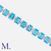 A Topaz and Diamond Bracelet in 18 carat white gold, comprising twenty-five emerald cut blue