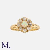 An Antique Opal and Diamond Cluster Ring in 18K yellow gold, set with a cabochon opal to the