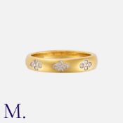 A Diamond Band in 18ct yellow gold, with three quatrefoil motifs set with round cut diamonds