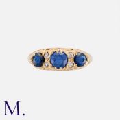 A Sapphire And Diamond Ring in 9k yellow gold, comprising three round cut sapphire punctuated by
