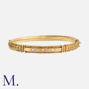 An Antique Etruscan Revival Style Bangle in yellow gold, set with a trio of round cut diamonds,