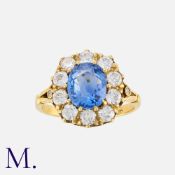 A Sapphire and Diamond Cluster Ring in 18 carat yellow gold, comrpsising a central cushion cut