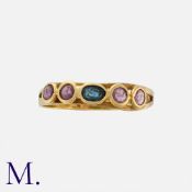 A Ruby and Sapphire Ring in 18 carat yellow gold, set with a central oval cut sapphire, flanked