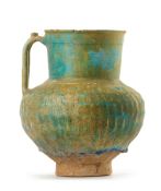 AN IRIDESCENT TURQUOISE BLUE GLAZED POTTERY JUG, KASHAN, 12TH CENTURY