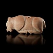 A STAMP SEAL IN THE SHAPE OF A BULL RECLINING TO THE LEFT IN PINK CALCITIC LIMESTONE, 3RD MILLENNIUM