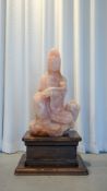 A large Chinese carved rose quartz sculpture of Quan Yin holding a ruyi scepter