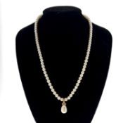 Cultured pearl and diamond necklace. The slightly graduated 4.0-4.4mm cultured pearls suspending