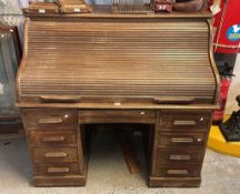 Early 20th century oak roll top desk, with pedestal base and fitted interior, the lock marked
