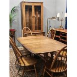 20th century Ercol elm and beech dining room suite comprising: refectory style extending dining