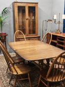 20th century Ercol elm and beech dining room suite comprising: refectory style extending dining