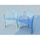 A pair of painted metal garden chairs.