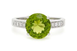Bague or gris 750 sertie d'un péridot épaulé de diamants taille brillant, doigt 52-12