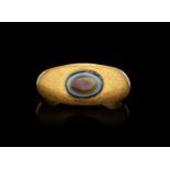 A RARE ROMAN AGATE "DZI" EYE BEAD ON A GOLD RING, CIRCA 1ST CENTURY A.D.