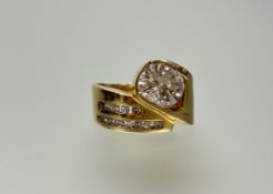 A yellow metal 60s-style scrolling ring set brilliant cut diamond of oval rounded shape,