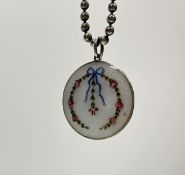 An early 20thc Norwegian guioche enamel sterling silver circular pendant with ribbon and rose design