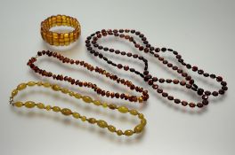 A dark cherry flat bead necklace: l. x 56cm 29.3g, an amber nugget bead necklace with ring