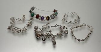 A heavy silver double link chain bracelet mounted with eleven various charms to include a shoe, a