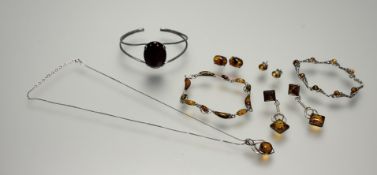 A collection of silver and white metal jewellery mounted with Baltic amber to include a scrolling