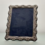 A Sheffield silver chased photograph frame with blue cotton velvet back and easel stand Sheffield