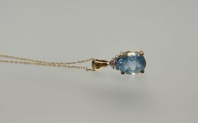A yellow metal pendant set oval cut topaz, approximately 2ct and diamond point on fine trace link