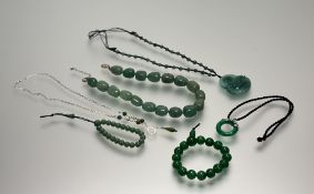 A modern celadon green jadeite polished stone necklace: l. x 20cm, a dyed intense green bead