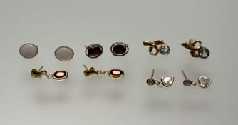 A pair of 9ct gold aquamarine stud earrings: l. x 1.5cm and a pair of 9ct gold red stone oval stud