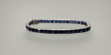 A white metal blue paste set line bracelet with clip fastening: d. x 7cm