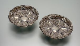 A pair of late Victorian Birmingham silver pierced and chased nut dishes raised on three ball