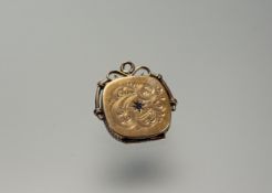 An Edwardian yellow metal squared pendant locket with engraved scrolling design and plain
