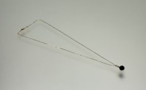 A yellow metal mounted royal blue faceted bead mounted on yellow metal trace link chain: l. x 24cm