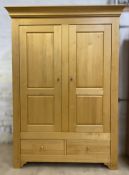 A contemporary solid oak double wardrobe, moulded cornice over twin inset panel doors, with