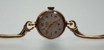 A 9ct gold Majex wristwatch on 9ct gold twin snake link adjustable strap with cream enamel dial with