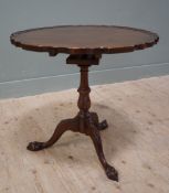 A reproduction mahogany tilt-top occasional table, in the Chippendale style, the circular top with